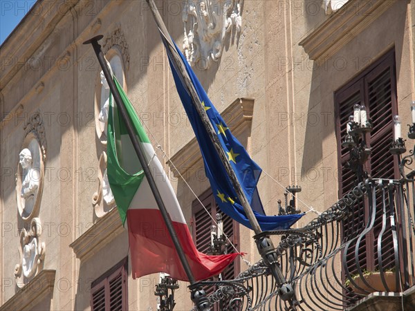 A building with an Italian and European flag, restrained historical architecture, palermo in sicily
