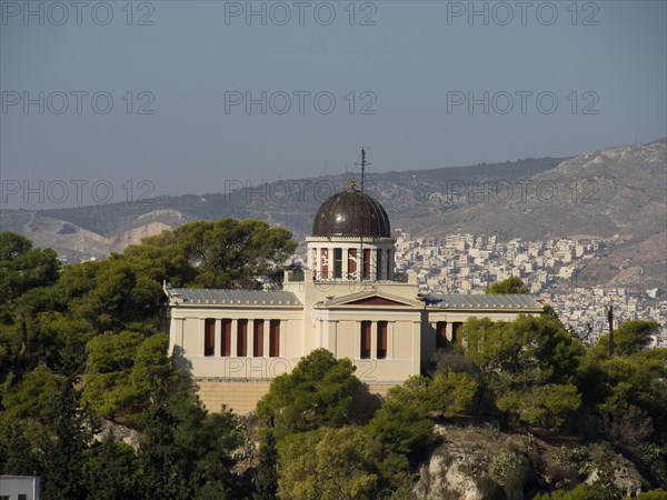 Historic building on a hill surrounded by trees overlooking a city, Ancient building with columns