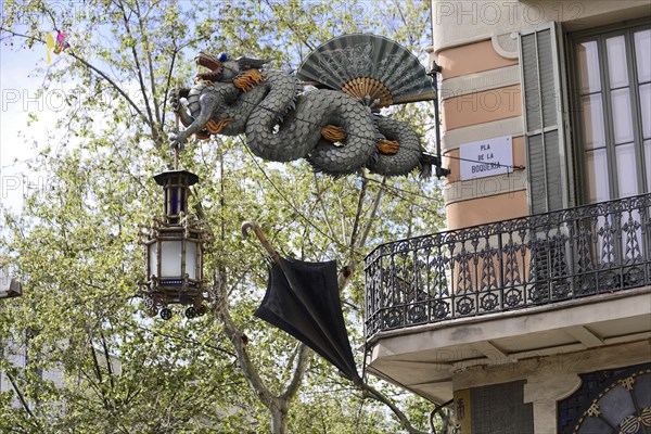 Barcelona, Catalonia, Spain, Europe, Dragon statue carrying a decorative lantern and an umbrella in