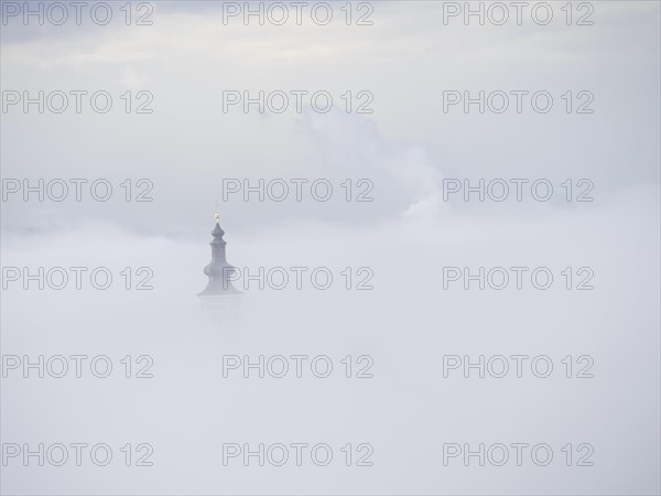 Church tower rises out of the morning mist, Frauenberg pilgrimage church, near Leibnitz, Styria,