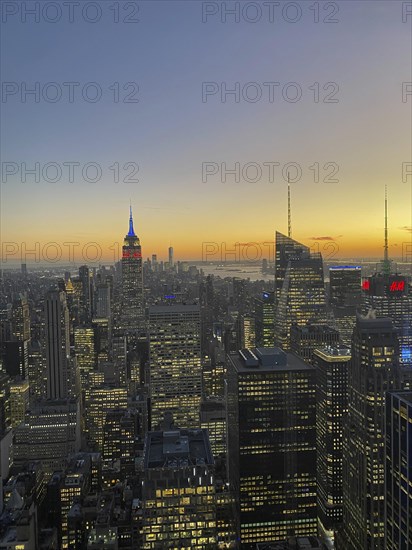 Cityscape at sunset with various skyscrapers and the empire state building in the background, the