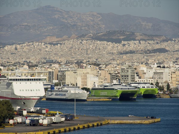 View of a harbour with several ships in front of a city and mountains, Ancient buildings with