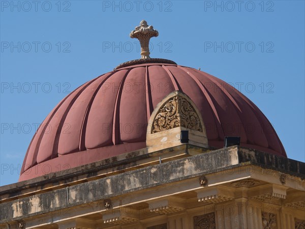 A red dome on a historic building under a clear blue sky, palermo in sicily with an impressive