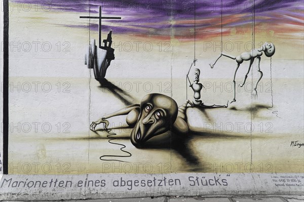 Marc Engel, Painting marionettes of a detached piece by Marc Engel on a remnant of the Berlin Wall,