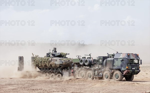 A Cougar infantry fighting vehicle is unloaded from a Mammut heavy goods transporter during the