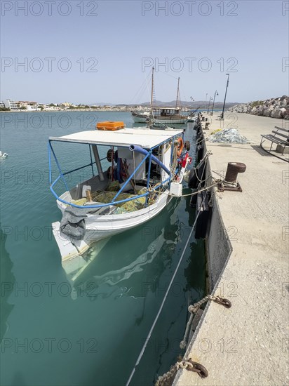 Fishing boat moored to quay wall in Kokkinos Pyrgos harbour, fishing nets on board, Kokkinos