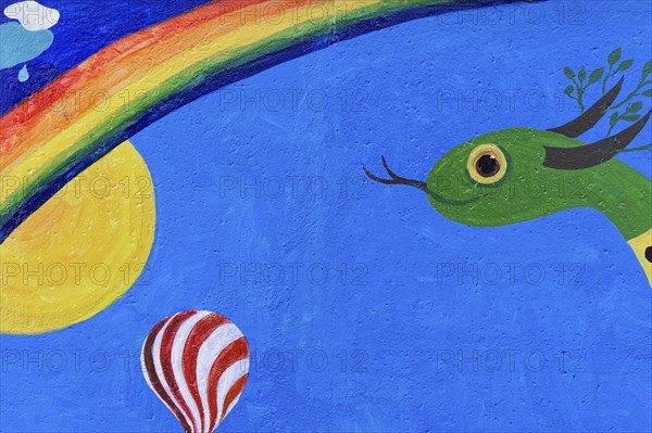Colourful mural with a snake, sun, rainbow and a hot air balloon under a clear sky, mural, East