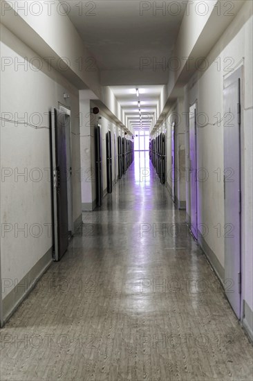 Narrow corridor with neon lights and open doors leads into the distance, Berlin-Hohenschoenhausen