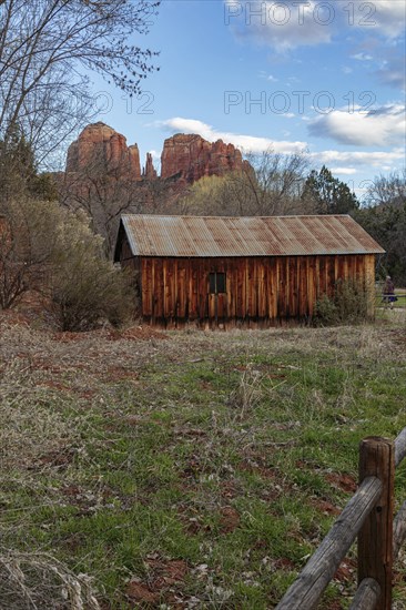 Cathedral Rock sandstone formations tower over a rustic barn at the Crescent Moon Picnic Site in
