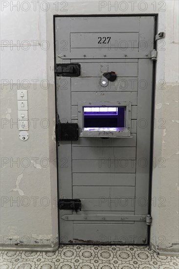 Close-up of a security prison door with food window and worn walls, Berlin-Hohenschoenhausen
