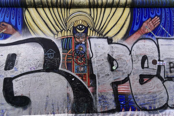 Mural showing an angel with wings, overlaid with graffiti and scribbles on an urban wall, mural,