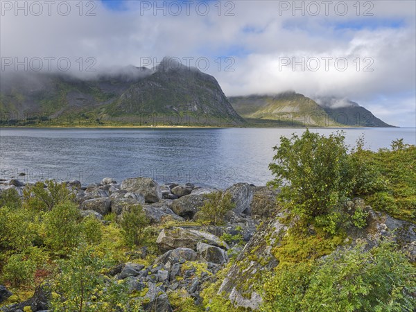 Rocky coast of Tungeneset, fog and blue sky, Senja, Norway, Europe