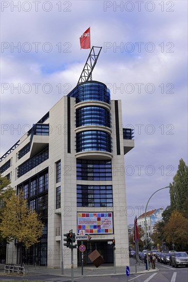 A modern office building on a street corner with a flag and autumnal trees, Willy-Brandt-Haus, SPD