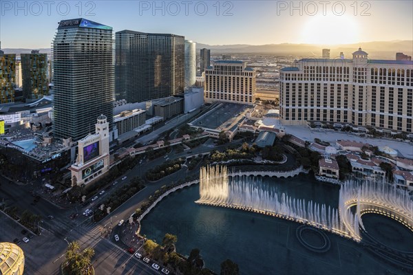 Sun setting behind the Bellagio Casino during a fountain show on the strip in Las Vegas, Nevada,