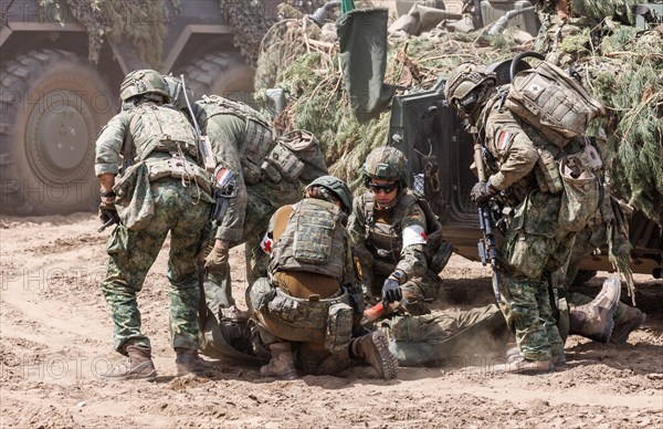 German and Dutch soldiers care for a simulated injured comrade as part of the NATO large-scale