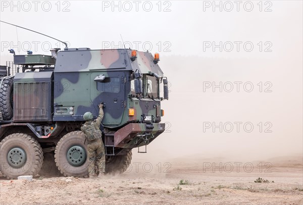 A Cougar infantry fighting vehicle is unloaded from a Mammut heavy goods transporter during the