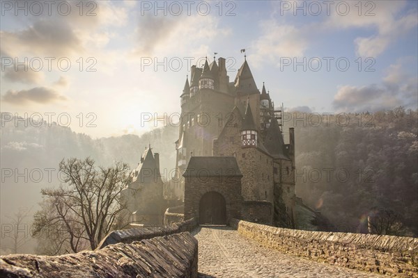 View of Eltz Castle. A landscape in autumn on a frosty morning with ripe and fog. The famous castle