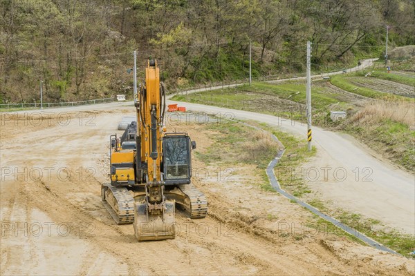 Front view of backhoe parked at rural construction site in Daejeon, South Korea, Asia