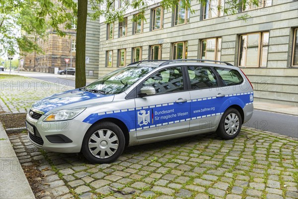 A car similar to a police car advertising a bookshop is parked in the government district of