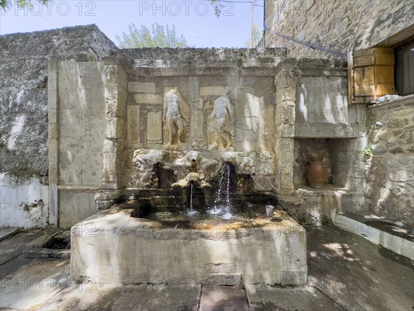 Venetian fountain depicting weathered relief of Adam and Eve in front of the Tor tor of Eastern