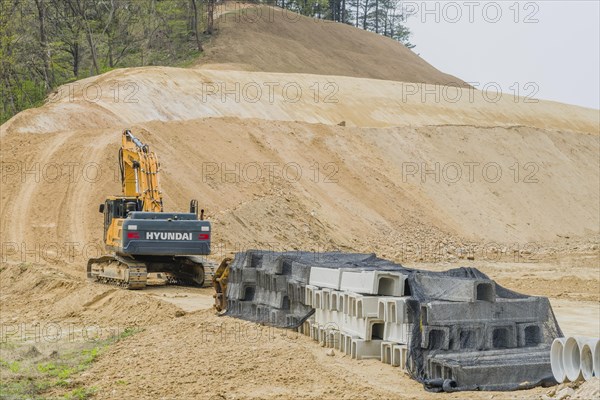 Hyundai backhoe parked at base of dirt hillside at construction site in Daejeon, South Korea, Asia