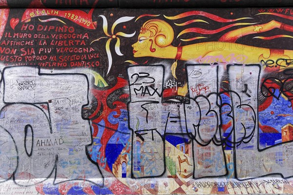 Colourful mural with a fiery female figure and Italian lettering, overlaid with large graffiti