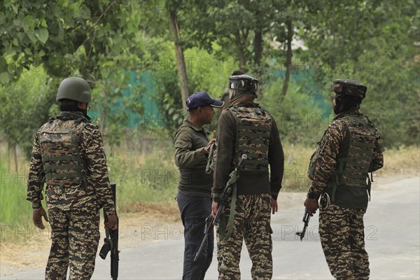 Soldiers in camouflage uniforms talking on a road, with weapons and gear visible, Encounter,