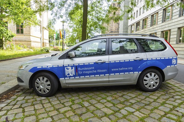 A car similar to a police car advertising a bookshop is parked in the government district of
