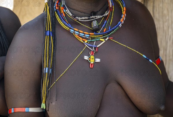 Detail, traditional necklace of a Hakaona woman, pearl necklaces with pendants, in the morning
