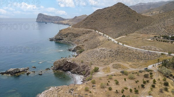Aerial view from elevated position on small hidden beach Loutra Beach in foreground below, right