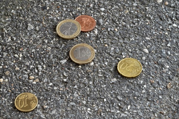 Money lying on the street, two one euro pieces, 20 cent, 10 cent, 5 cent