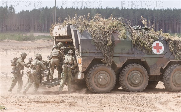 German and Dutch soldiers evacuate a simulated injured comrade as part of the NATO large-scale