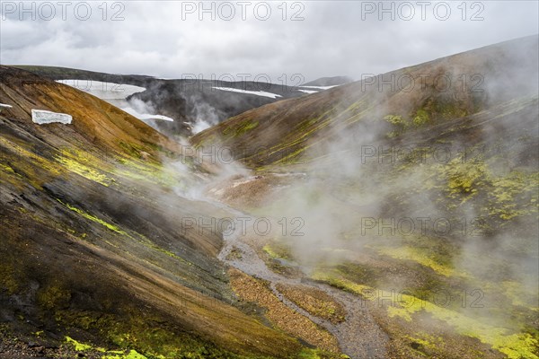 Colourful volcanic landscape with hills and snow, volcanic steaming hot springs, Laugavegur