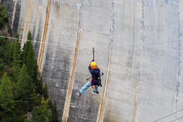 Child on zipline above reservoir dam, Barrage de Emosson, Finhaut, Switzerland, Europe