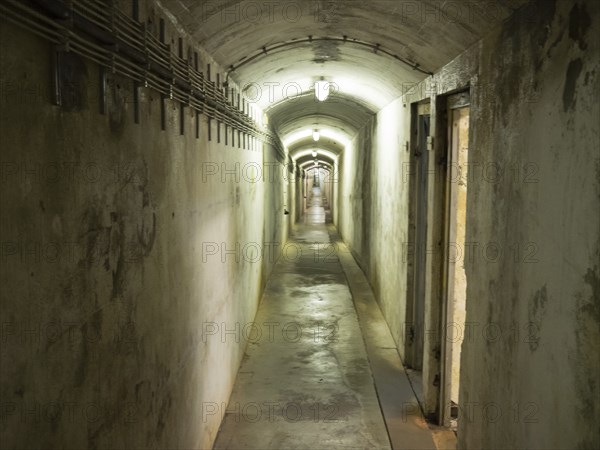 A long, closely lit tunnel with concrete walls and an oppressive atmosphere, helgoland, germany