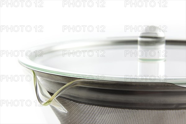 A teapot with a large tea strainer against a white background