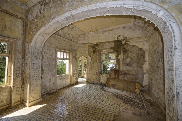 Dilapidated room with arched architecture, dilapidated walls and flooded with bright natural light,