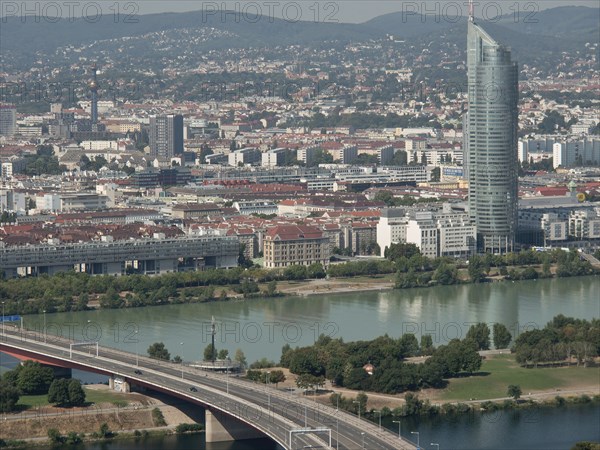 Panorama of an urban landscape with a dominating skyscraper next to a river, Vienna, Austria,