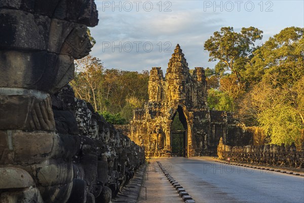 Stone Gate of Angkor Thom in Cambodia illuminated by the setting sun