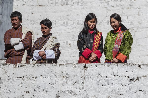 Bhutanese people in traditional clothes watching the annual Tsechu of Trongsa Dzong, Bhutan, Asia