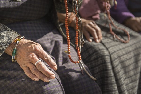 Close-up of old woman's hands with prayer beads