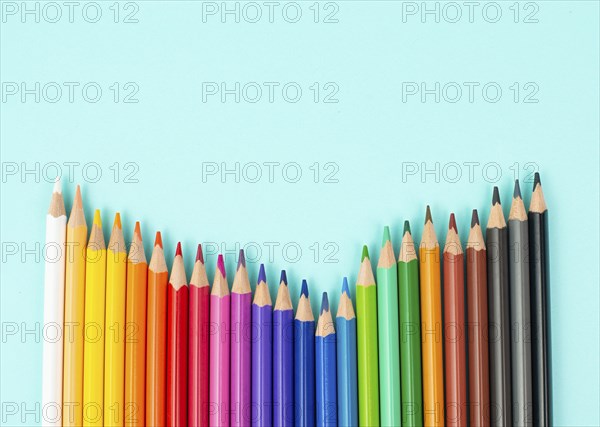 Color pencils collection in a row, back to school, drawing supplies, blue background with copy