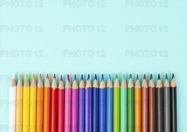 Color pencils collection in a row, back to school, drawing supplies, blue background with copy