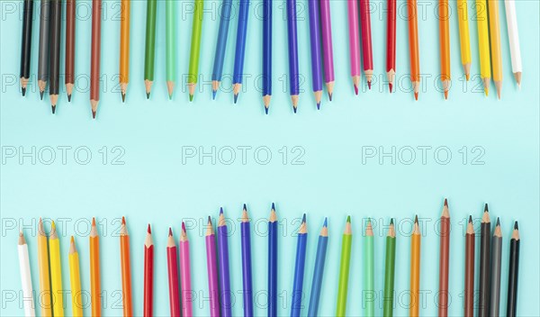 Color pencils collection in a row, back to school, drawing supplies, blue background with copy