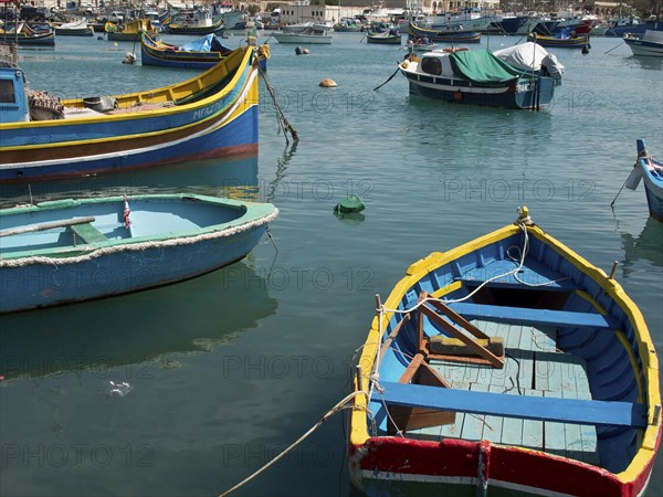View of several colourful boats floating on the water in the harbour, marsaxlokk, mediterranean
