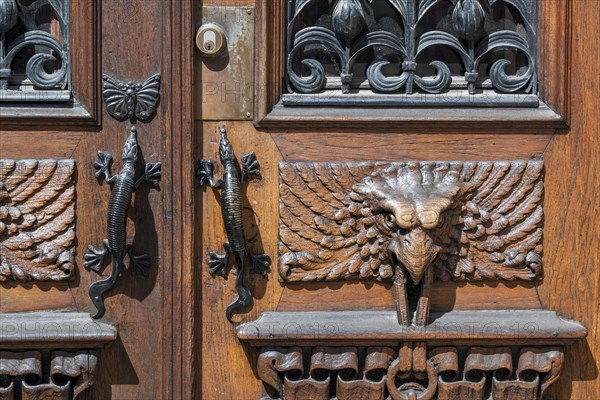 Detail, entrance door with gecko door handles and wood carvings in the shape of birds, Vasaplatsen,