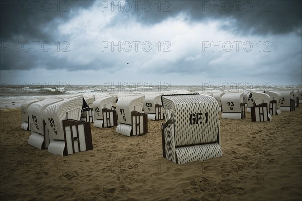 Roofed wicker beach chairs at the baltic sea beach, coast at the island of Usedom in Germany, storm