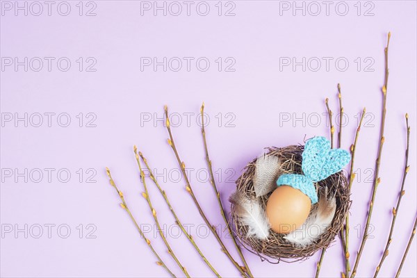 Easter bunny or rabbit in a bird nest, made from an egg and crocheted ears, spring holiday,