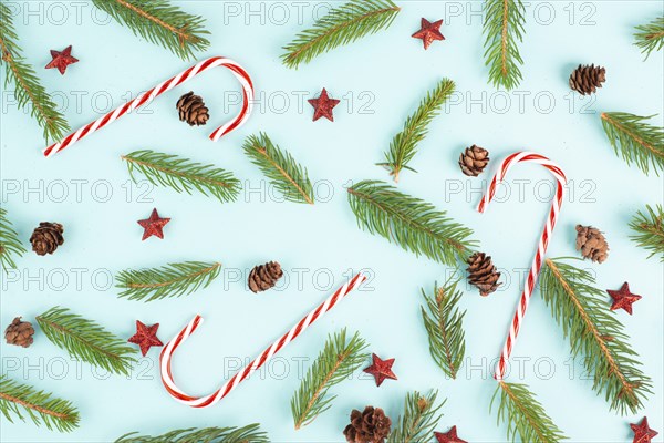 Christmas holiday background with candy cane, fir branches, pine cones and red stars, winter season
