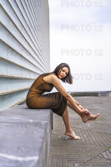 Portrait of an attractive middle eastern woman in the city. Fashion and glamor concept, sitting